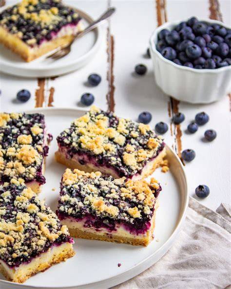 Streuselkuchen mit Blaubeeren und gehobelten Mandeln auf einem Kuchenteller