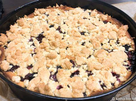 Streuselkuchen mit gemischten Beeren und Pudding, angeschnitten auf einem Kuchengitter