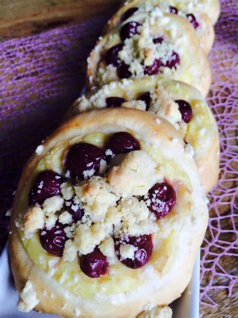 Streuseltaler mit Pudding und Kirschen - Zutaten und fertige Taler auf Holzbrett, nah aufgenommen
