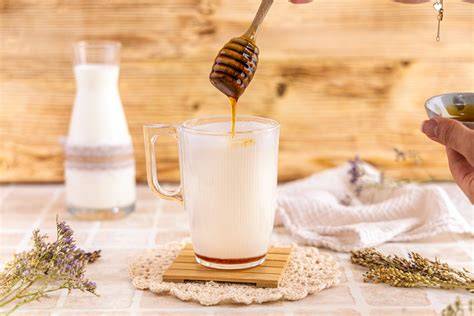 Tasse warme Milch mit Honig neben einem Duftstein