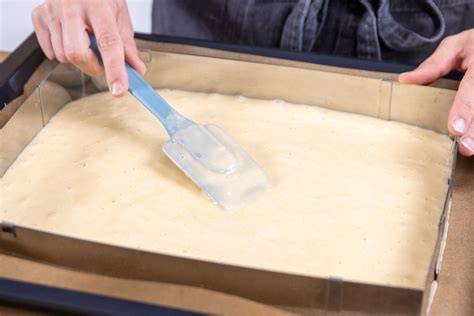 Teig auf dem Backblech glatt gestrichen vor dem Backen