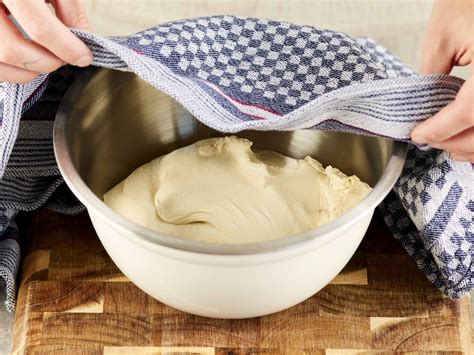 Teig in der Schüssel mit feuchtem Tuch bedeckt