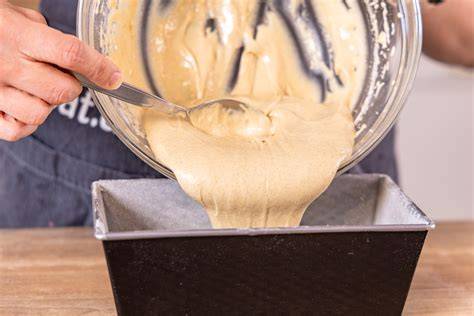 Teig mit Apfelstücken in der Backform vor dem Backen