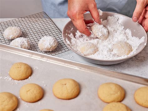 Teigkugeln im Puderzucker rollen