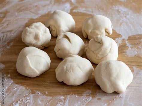 Teiglinge und Marzipanraspel auf bemehlter Arbeitsfläche