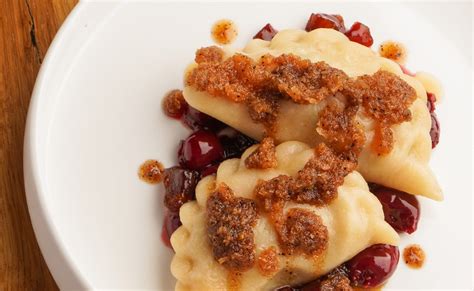 Teigtaschen mit Apfel- und Kirschfüllung auf Backblech