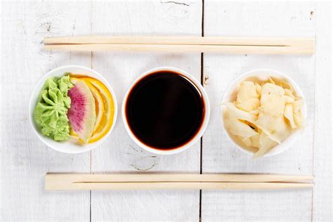 Tipp: Sushi-Torte in Stücke geschnitten, serviert mit Stäbchen, Sojasosse, Ingwer und Wasabi