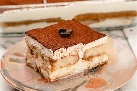 Tiramisu-Torte mit Löffelbiskuits ohne Ei, serviert auf italienischer Keramik