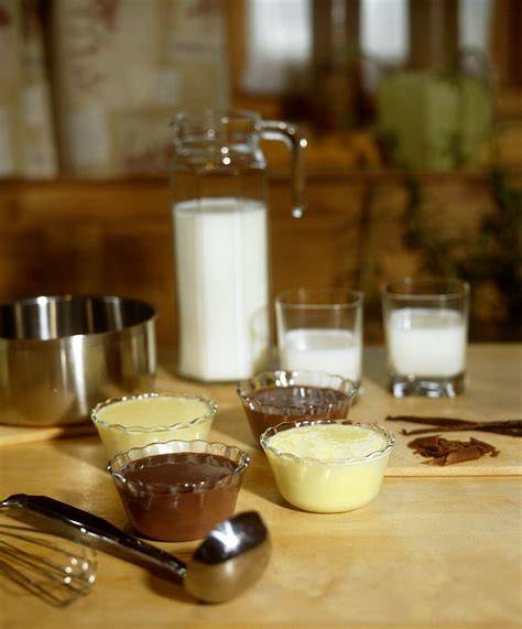 Tisch mit Zutaten für Schoko- und Vanillepudding