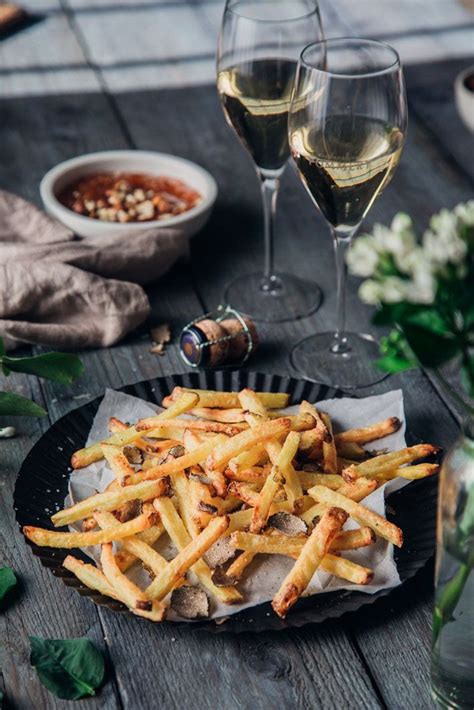 Tischszene: Trüffelpommes, verschiedene Dips und Champagner