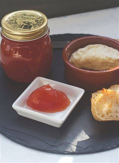 Tomatenmarmelade serviert mit Käse und frischem Brot