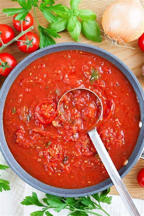Tomatensauce in Zubereitung mit frischem Gemüse
