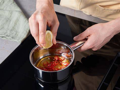 Topf mit Honig und Chili beim Erwärmen