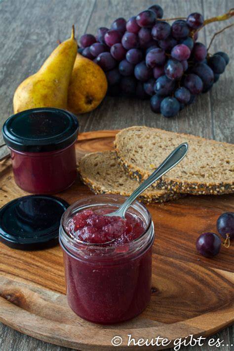 Topf mit einkochender Birnen-Trauben-Marmelade, Vanilleschote daneben
