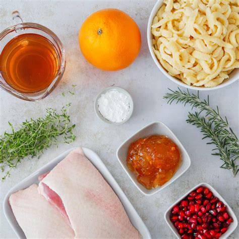 Topf mit einkochender Orangensauce und Rosmarin, Thermometer zeigt Temperaturen