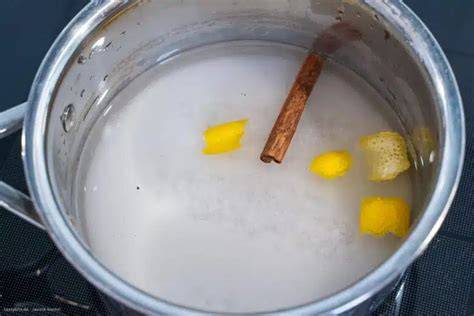 Topf mit köchelndem Zuckersirup und Zimtstange