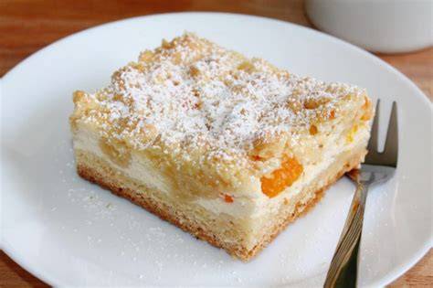 Topfenkuchen mit goldbraunen Streuseln auf Blech, Schnitt und Textur sichtbar