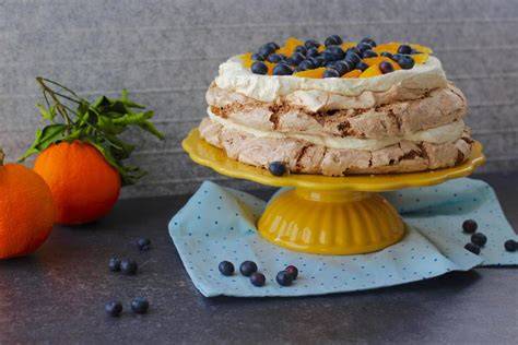 Torte mit Orangenfilets, -schale und Kuvertürehcokoladenröllchen