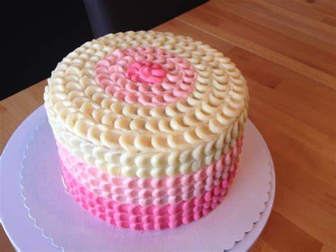 Torte mit pink eingefärbter Frischkäse-Buttercreme glatt eingestrichen