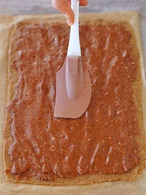 Tortencreme wird mit einem Spatel auf dem Boden verteilt