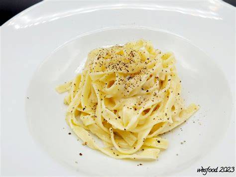 Trüffel, Parmesan, Tagliatelle und Trüffelbutter als Zutaten auf einer Holzplatte