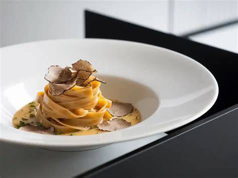 Trüffel-Pasta angerichtet auf Teller mit Parmesanhobel