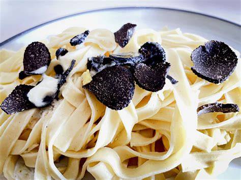 Trüffel-Pasta auf tiefem Teller mit frisch gehobeltem schwarzen Trüffel