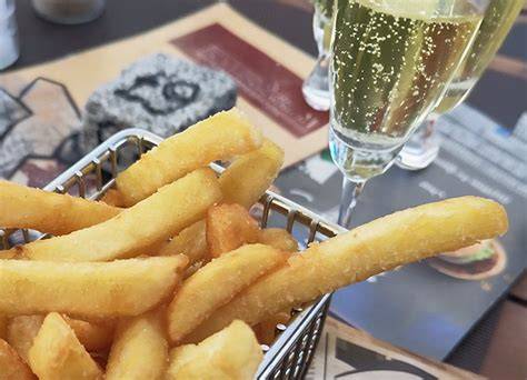 Trüffelchips auf Holzbrett neben Champagnerglas