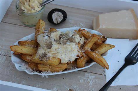 Trüffelmayonnaise auf hausgemachten Pommes mit Parmesan und Trüffelscheiben