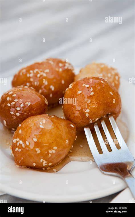Traditionelle griechische Loukoumades auf einem Teller, serviert mit Honig und Nüssen