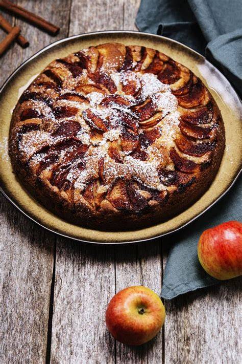 Traditioneller Apfelkuchen mit Mandeln, auf einem rustikalen Holztisch angerichtet