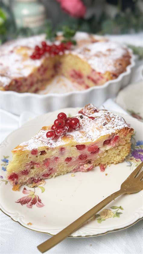 Traditioneller Johannisbeerkuchen mit Puderzucker und Minze auf einer Tortenplatte