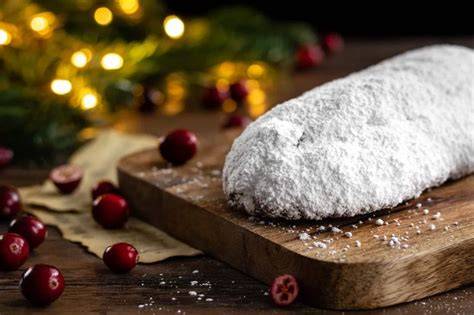 Traditioneller Marzipan-Stollen auf Holzbrett, von Puderzucker umhüllt