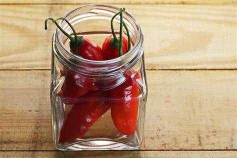 Trocknende Chilischnüre und eingelegte Chilis im Glas