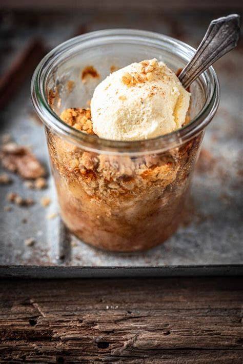 Vanilleeis neben einem Löffel Crumble