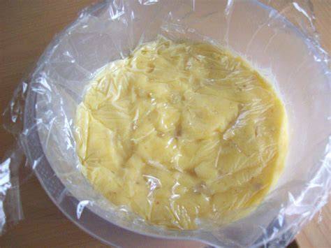 Vanillepudding in einer Schüssel mit Frischhaltefolie auf der Oberfläche