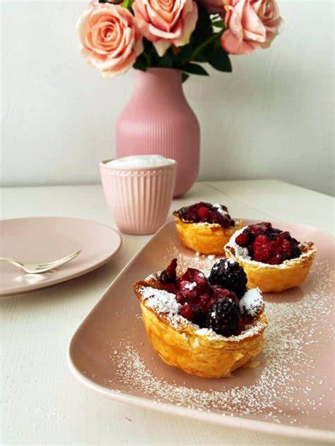 Vanillepudding mit Beeren und Schlagsahne serviert