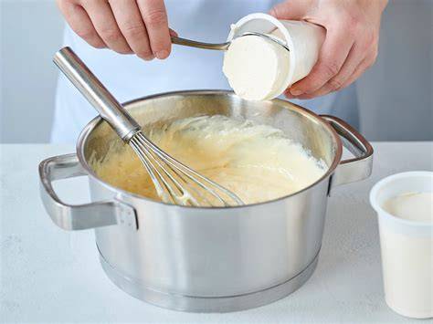Vanillepudding wird unter Schmand gerührt