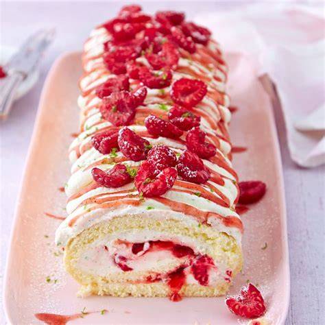 Variation: Mit roten Streifen versehene Biskuitrolle im Anschnitt dekoriert mit Sahne und Obst