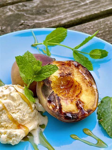 Variationen: gegrillte Pfirsichhälften mit Vanilleeis und Himbeer-Coulis im Glas serviert