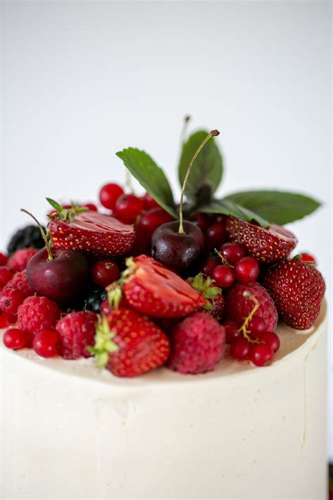 Vegane Hochzeitstorte dekoriert mit essbaren Blüten und frischen Beeren