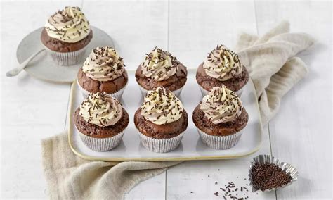 Vegane Kürbis-Schoko-Muffins auf einem Tablett, umgeben von Orangenschalen und Zimtstangen