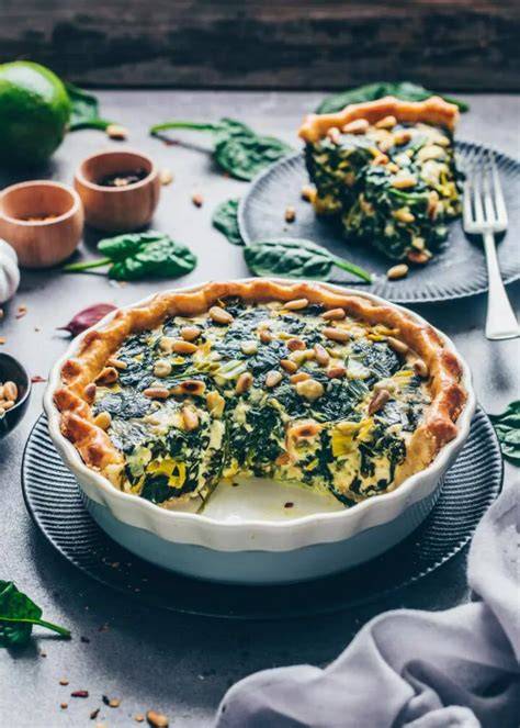 Vegane Quiche mit Spinat, Paprika und Pilzen, angeschnitten und serviert