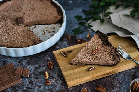 Vegane Schokoladen-Törtchen auf Holzbrett mit Kakaonibs