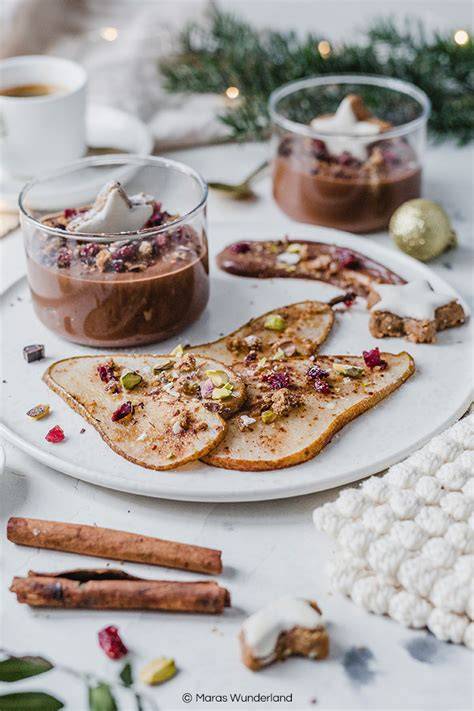Vegane Schokomousse mit gebackener Birne dekoriert mit Pistazien und Cranberries