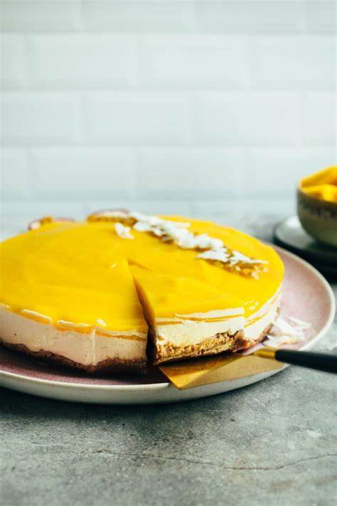 Veganer Mango Quark Kuchen auf Nussboden mit exotischer Dekoration