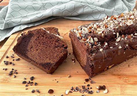 Veganer Schoko-Rührkuchen auf Holzbrett, angeschnitten, Saftigkeit sichtbar