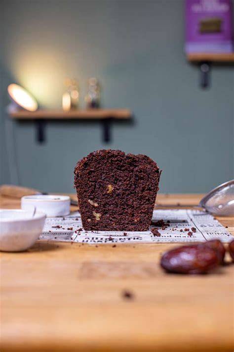 Veganer Schokokuchen mit Datteln auf Servierplatte, daneben Medjool-Datteln