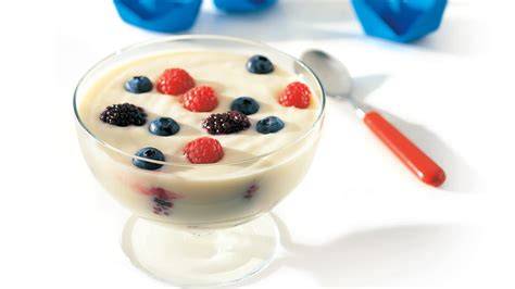 Verschiedene Beeren und Joghurt mit Zutaten auf einem Tisch