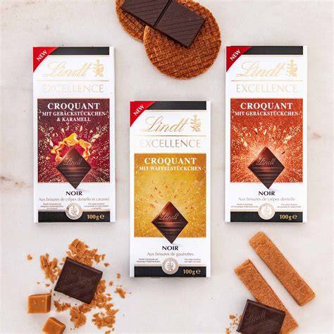 Verschiedene Lindt Tafeln und Zutaten (Zucker, Kakaobohnen, Milchpulver)